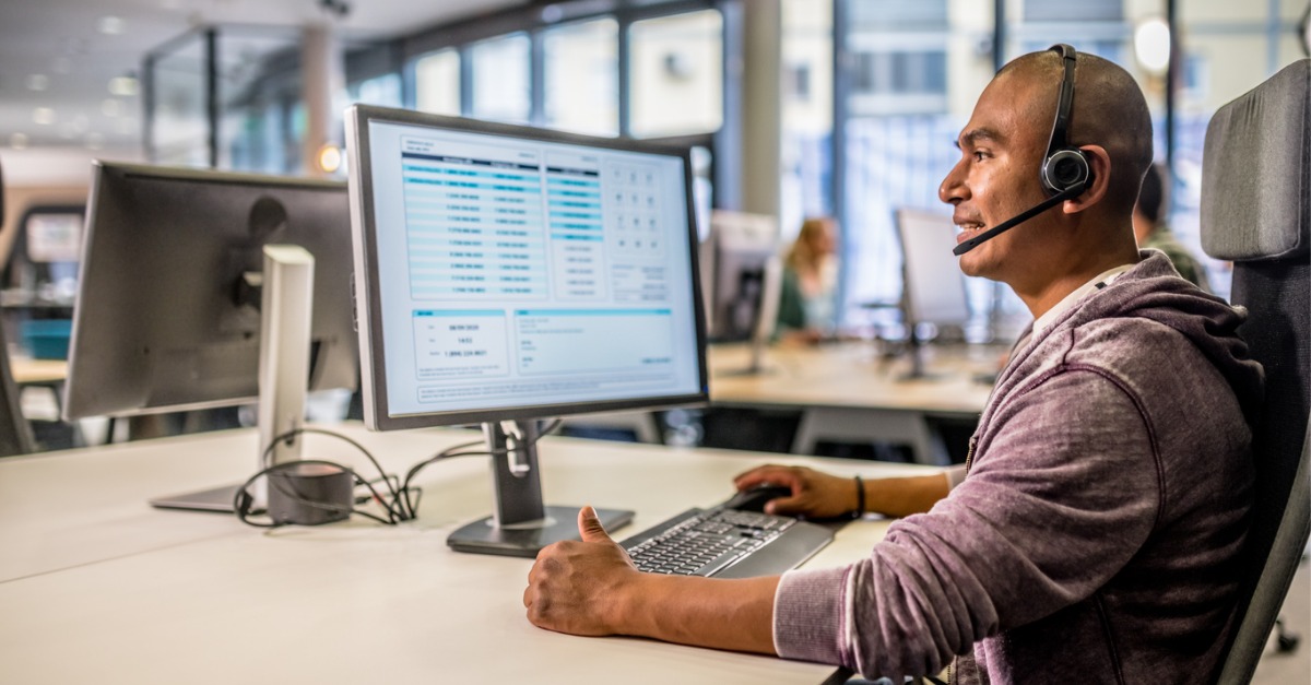 Photo showing a man working in a contact center with on-screen software that supports contact center staffing.