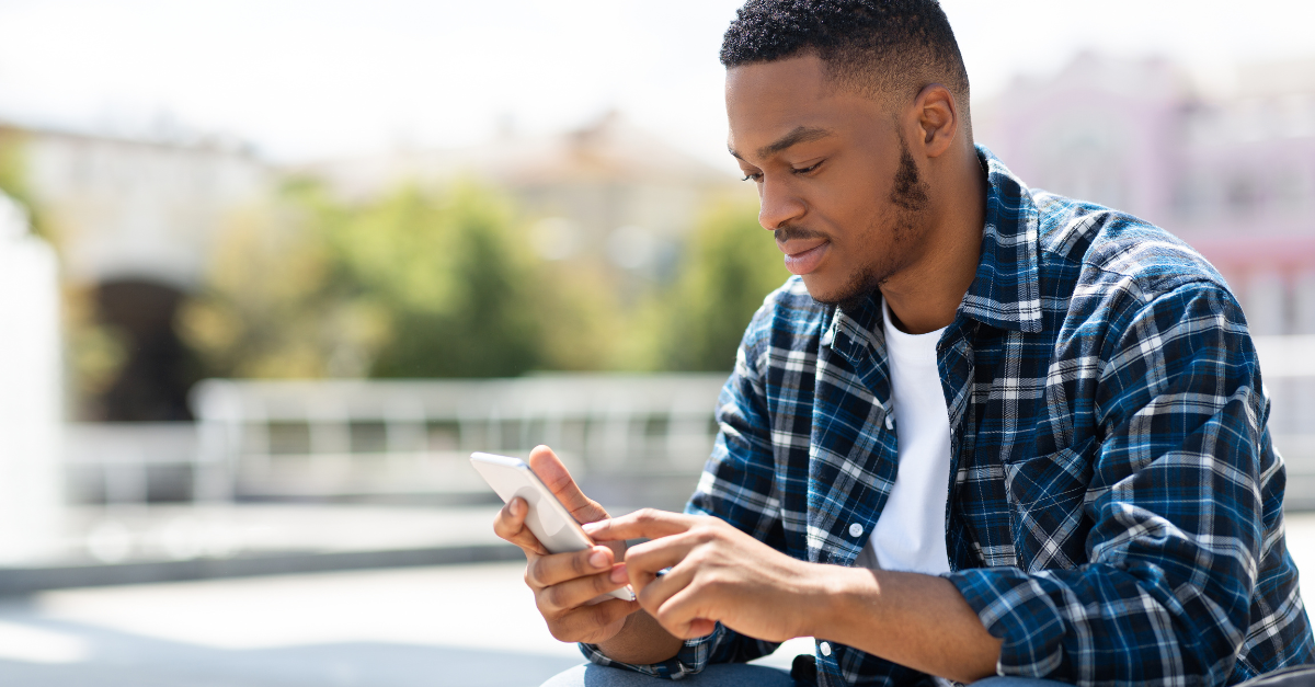 Photo of a customer engaging with a company on his phone using conversational AI, which helps the company reduce operational costs.